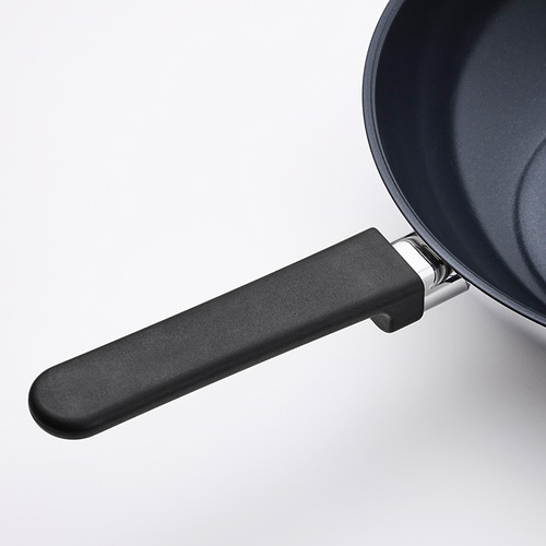 Sartén negra con mango resistente, interior antiadherente brillante, sujeta de forma segura al mango moderno para facilitar el agarre.
