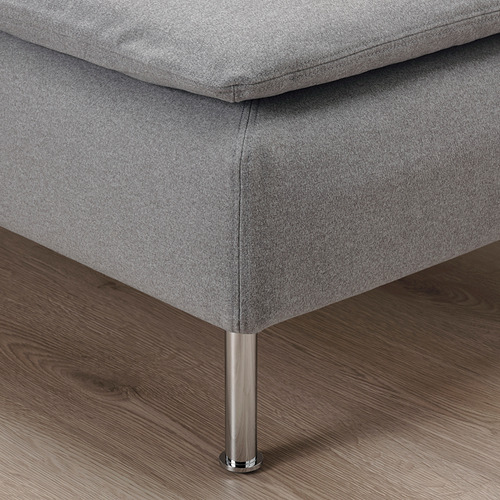 Primer plano de un moderno sofá tapizado en color gris sobre patas metálicas, de líneas limpias y tejido de calidad.