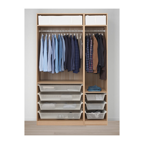 Armario abierto de madera con camisas y chaquetas colgadas, además de cestas de malla para ropa doblada.