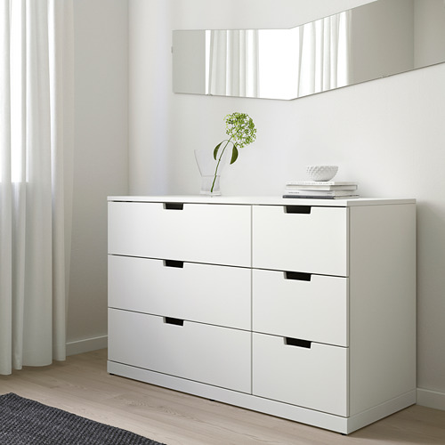 Ikea NORDLI cómoda de 6 cajones contra la pared, habitación minimalista, jarrón con flor verde, libros.