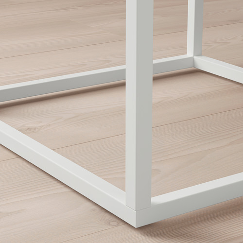Esta imagen muestra un primer plano de una estantería moderna de metal blanco con bordes lisos y líneas limpias, destacando su diseño robusto y contemporáneo.