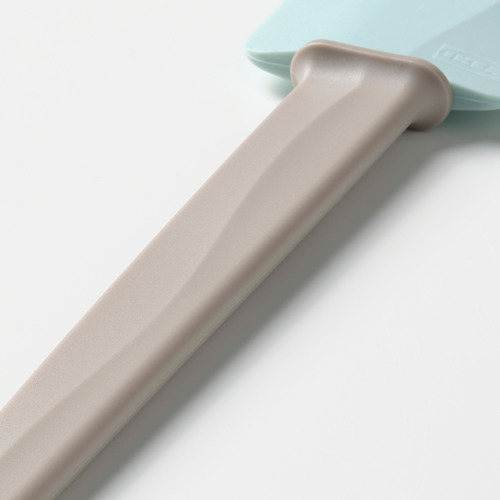 Espátula azul claro con mango beige, diseñada para un uso fácil y un soporte que no ensucie.