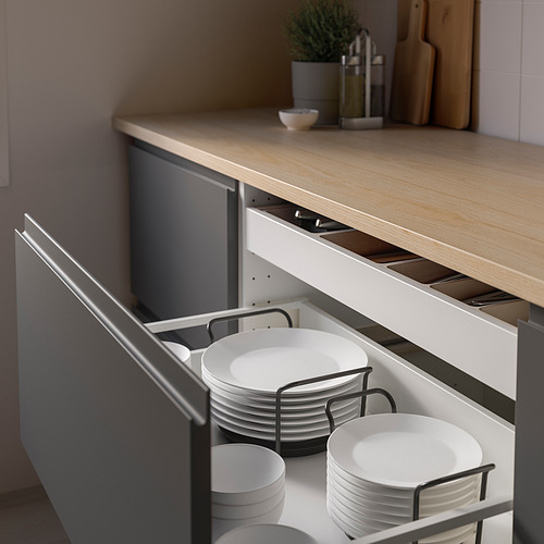 Cajón de cocina con organizador abierto que muestra platos blancos apilados sostenidos por soportes metálicos.