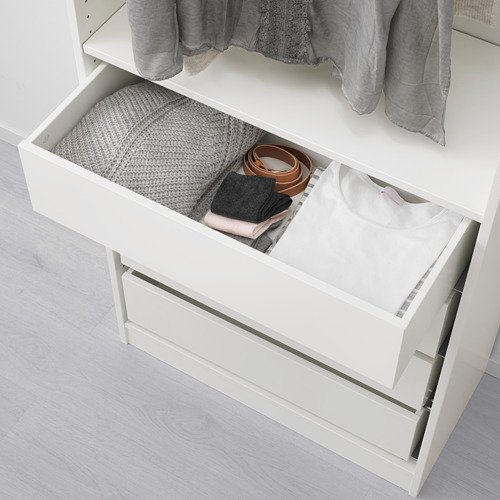 Cajón de armario blanco, abierto que muestra ropa doblada y accesorios cuidadosamente organizados en compartimentos.
