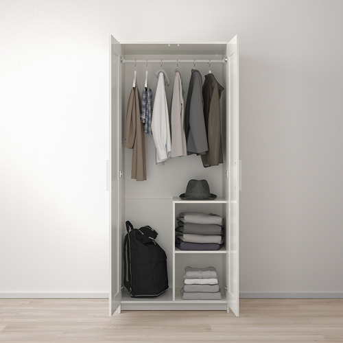 Armario blanco con barra de ropa, perchas y ropa doblada en estantes.