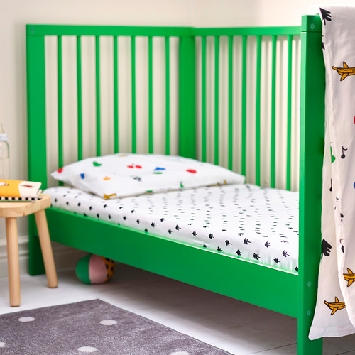 Cama infantil GRÖNFINK verde con sábana con estampado de árboles, taburete pequeño de madera y juguetes. Moderno, seguro y lúdico.