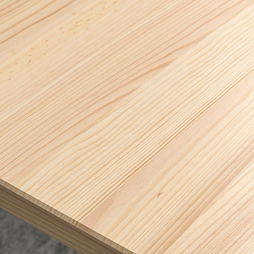 Primer plano de la superficie de madera lisa y de color claro, que muestra una textura de grano fino y un acabado pulido.