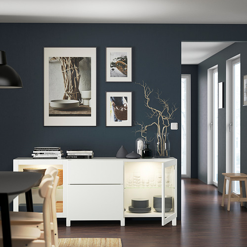 Comedor moderno con aparador BESTÅ, fotos y mesa negra.
