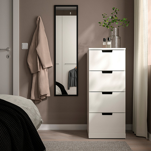 Dormitorio moderno con espejo LILJETRÄD, tocador blanco y detalles en verde.