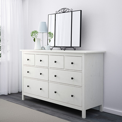Cómoda de madera blanca con cajones, espejo y lámpara.