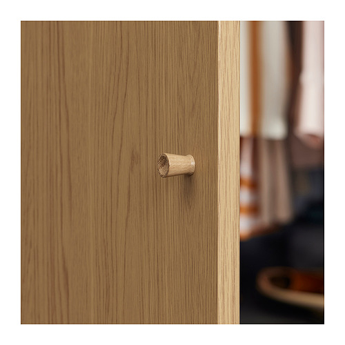 Pequeño gancho de madera sobre superficie de madera marrón claro, diseño sencillo y minimalista.