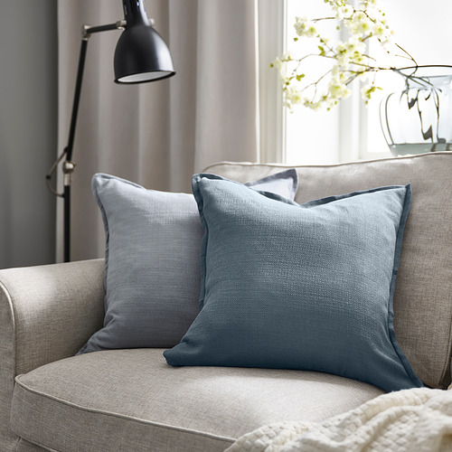 Silla moderna con almohada cuadrada LAGERPOPPEL gris azulado, acento floral, lámpara elegante, decoración neutra.