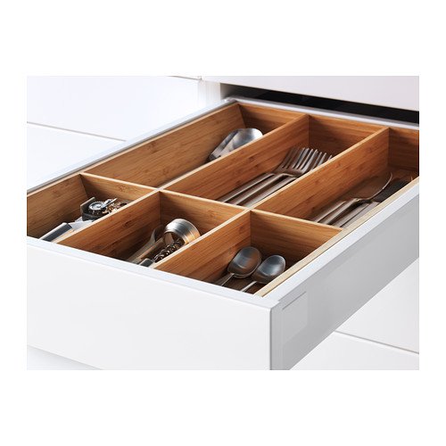 Cajón de cocina blanco abierto que muestra organizadores de utensilios de bambú sosteniendo tenedores, cucharas y otros cubiertos.