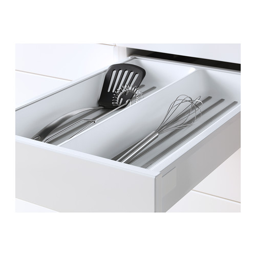 Cajón de cocina blanco con utensilios: cuchara ranurada, batidor, herramientas metálicas, función de cierre de deslizamiento suave.