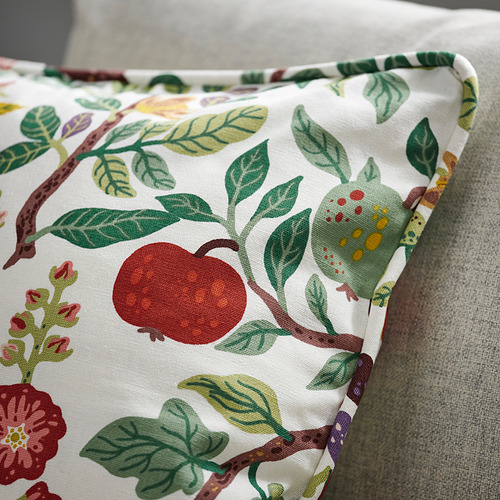 Cojín decorativo con diseño floral de algodón/lino reciclado sobre sofá.