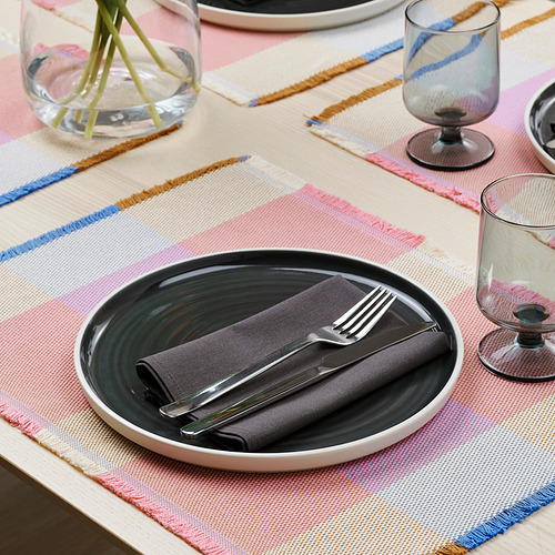 Mesa a rayas con mantel individual, plato, cubiertos y vasos.