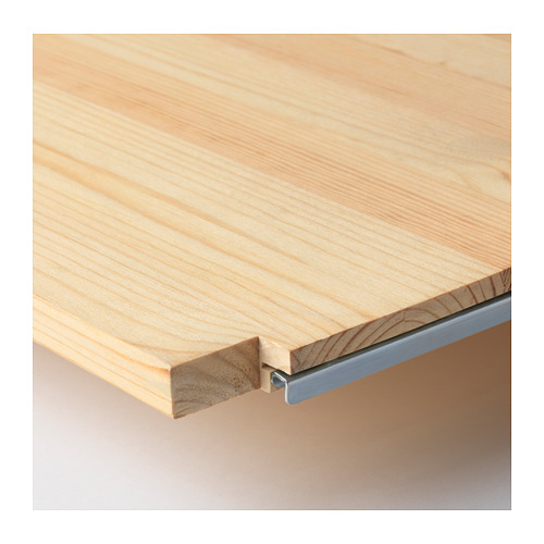 Primer plano del borde de la estantería de madera IVAR, que muestra madera de pino lisa y soporte metálico.