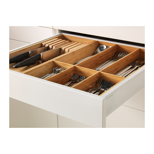 Muestra un cajón de cocina blanco con organizador de bambú, que sostiene cuchillos, cucharas y tenedores, lo que demuestra el cierre automático y el funcionamiento suave.