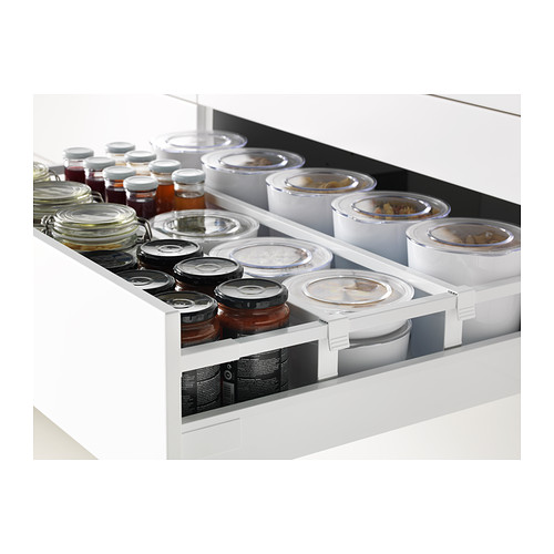 Cajones de cocina blancos con múltiples frascos y recipientes cuidadosamente organizados, mostrando el diseño suave y espacioso.