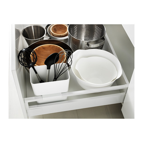 Cajón de cocina blanco con organizador: cuencos, utensilios, colador y recipientes.