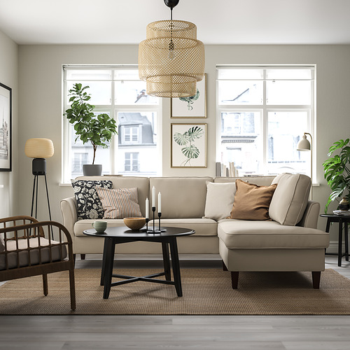 Moderno salón con sofá EKHOLMA beige, mesa de centro de madera, alfombra gris y grandes ventanales. El sofá es grande con un diseño cómodo y elegante.