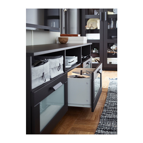Moderno mueble de entretenimiento con amplios cajones y cableado, negro con frentes de cristal.