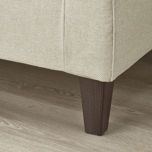 Un sofá moderno con patas de madera cónicas y tela texturizada tapizada.