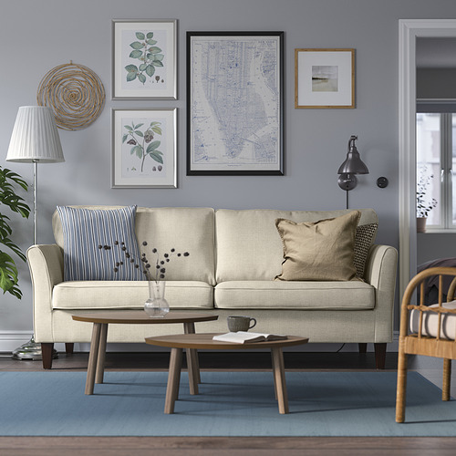 Sala de estar con sofá beige, paredes azules, alfombra, mesa de centro y decoración.