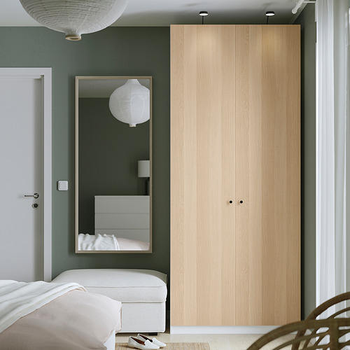 Dormitorio moderno y minimalista con armario PAX en madera clara, espejo y decoración blanca.