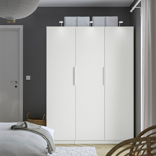 Dormitorio minimalista con gran armario blanco PAX, paredes grises y cesta de mimbre al lado.