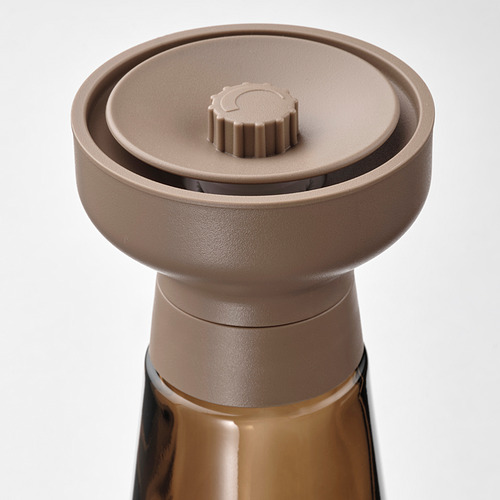 Parte superior de un elegante frasco de especias con un molinillo de cerámica, diseñado para uso en la cocina y el comedor.