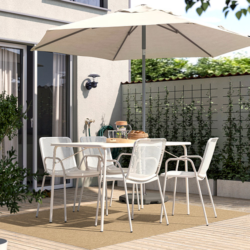 Alfombra LÄTTBETONG beige en el patio con sillas y sombrilla, acogedor comedor al aire libre.