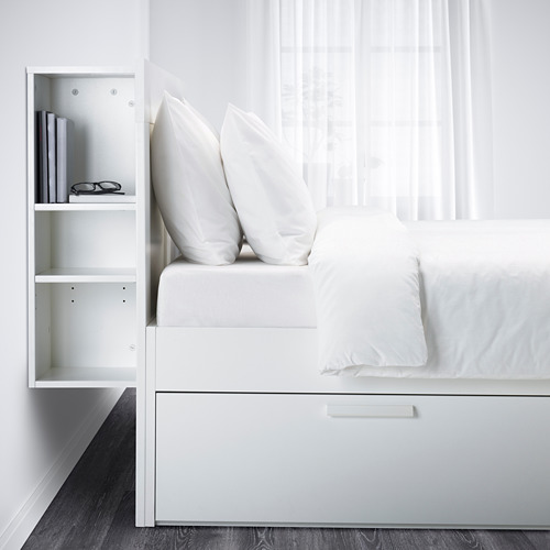 Una moderna cama blanca con cajones de almacenamiento incorporados debajo de la estructura y un compartimento para la cabecera, ideal para espacios pequeños.