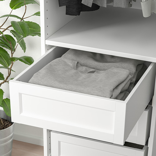 Un cajón blanco con tela gris en su interior, parte de un sistema organizativo. Está diseñado para un fácil almacenamiento y acceso a artículos como la ropa.