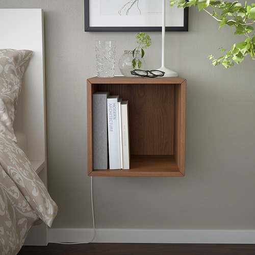 Armario de pared de madera marrón con libros y decoración en el dormitorio.