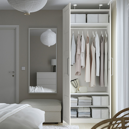 Dormitorio moderno con armario PAX y espejo, que ofrece un almacenamiento ordenado.
