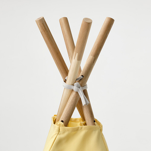 Postes de madera de la tienda atados entre sí, insertados en una bolsa de tela amarilla.