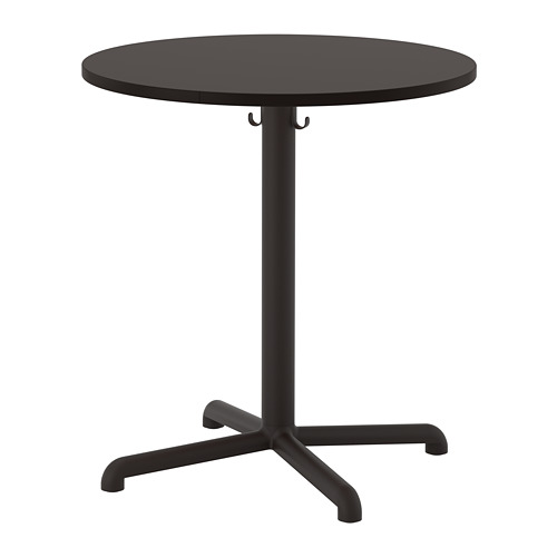 Representa una mesa STENSELE redonda y negra con un diseño elegante, con un soporte central y cuatro patas estabilizadoras, ideal para cafeterías o espacios pequeños.