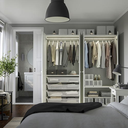 Dormitorio moderno con armario empotrado, lámpara colgante, cama y baño con ducha.