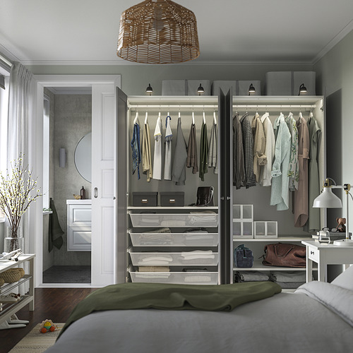 Dormitorio moderno con armario abierto que muestra ropa, estantes, cestas y una mesa auxiliar con una lámpara, que muestra el almacenamiento interior organizado.