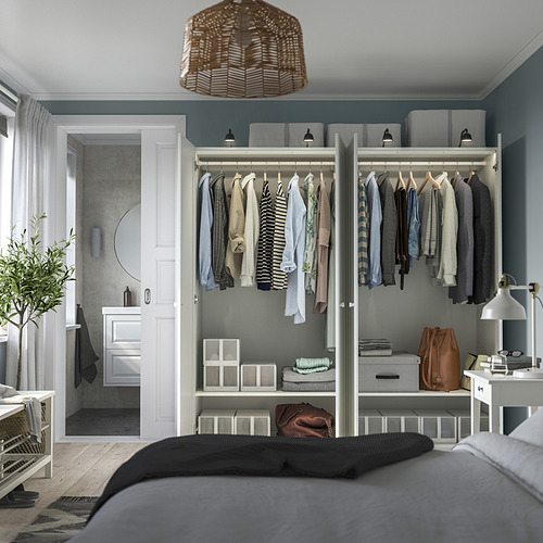 Dormitorio moderno con armario PAX, ropa, estanterías y almacenaje. Bisagras de cierre suave, pies ajustables. Cama de manta oscura, puerta del baño.