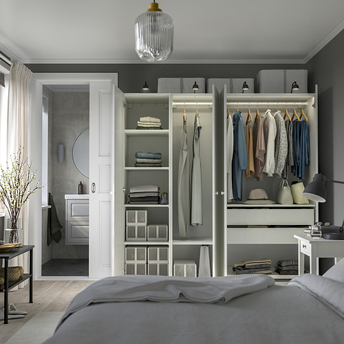 Dormitorio ordenado con armario abierto que muestra ropa organizada, estantes y cajones, con pies ajustables y luces integradas.