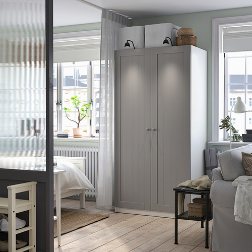 Interior moderno con armario PAX gris, luces, cerca de ventanas y muebles.