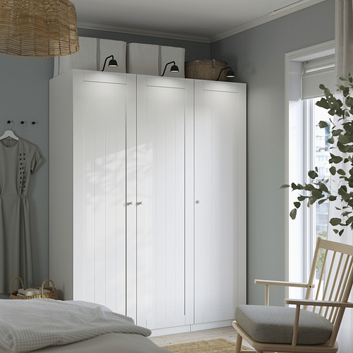 Dormitorio moderno con armario PAX de ikea, cama, silla y decoración.