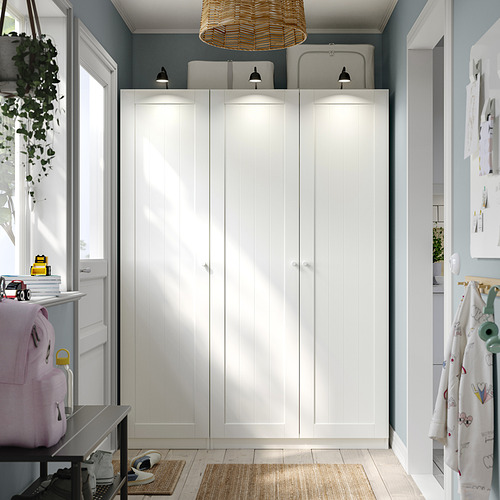 Armario PAX blanco moderno con luces, pared azul, muebles más pequeños.