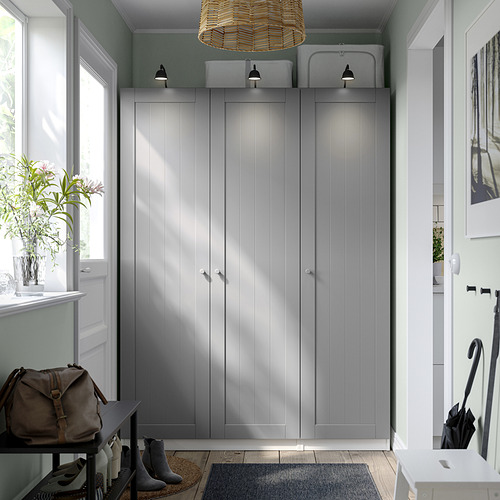 Moderno armario PAX gris con lámpara colgante, mesa, jarrón y paragüero.