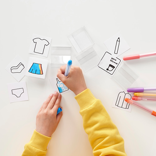 Manos de niño en color amarillo con marcador azul en tarjetas de etiqueta para organizar.