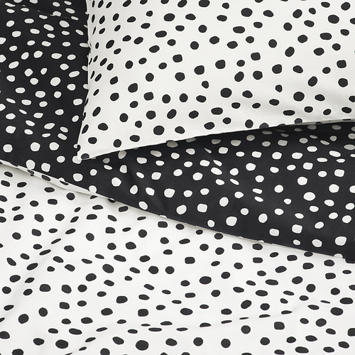 Ropa de cama de lunares blancos y negros, suave mezcla de algodón y viscosa, cuidadosamente dispuesta.