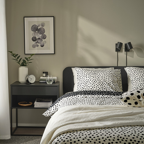 Dormitorio moderno con ropa de cama BJÖRKGRÅMAL con puntos negros sobre blanco, suave mezcla de algodón y viscosa, ropa de cama cuidada y acogedora cabecera.