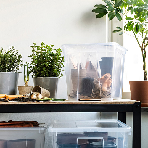 Caja SAMLA con cuerdas/herramientas en el estante de plantas.